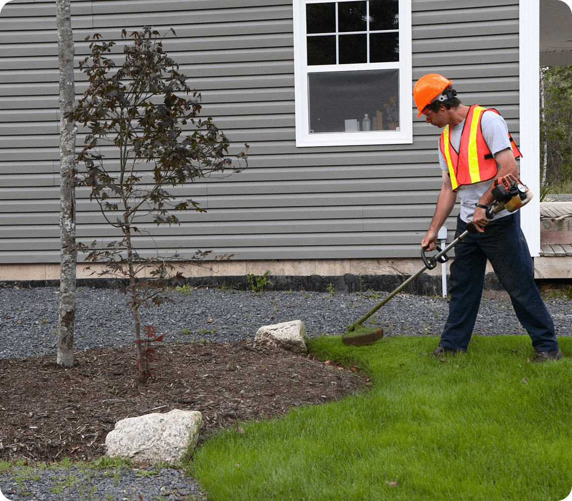 Man using grass trimmer outside home