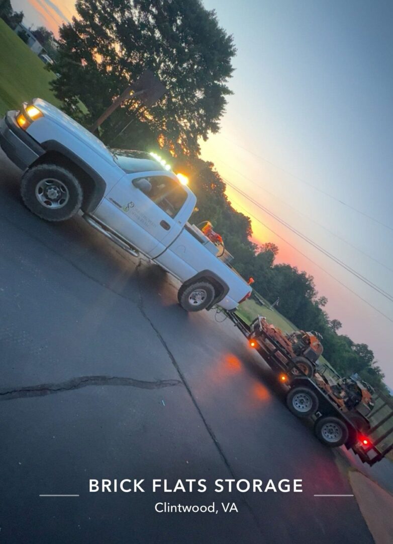 Truck and trailer at sunset, rural road.